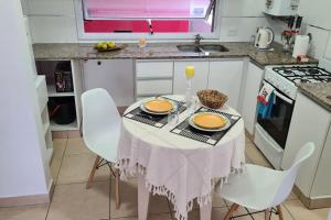 a kitchen with a table with chairs and a sink at Altos del Rey Apartamentos in San Salvador de Jujuy