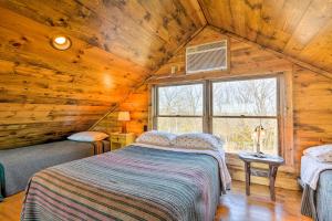um quarto num chalé de madeira com uma cama e uma janela em Greenfield Cabin with Screened-In Porch and Fire Pit! em Greenfield