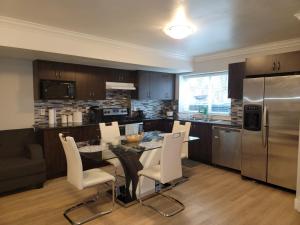 a kitchen with a table and chairs and a refrigerator at Oscar INN & 2bd Family Suite and Private Room in Abbotsford