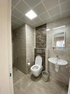 a bathroom with a toilet and a sink at Vesta Apart Hotel in Kuşadası +19 photos