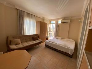 a living room with a bed and a couch at Vesta Apart Hotel in Kuşadası