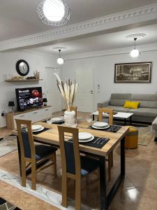 uma sala de estar com uma mesa e cadeiras e um sofá em Daily rent apartment city center Elbasan 6 em Elbasan