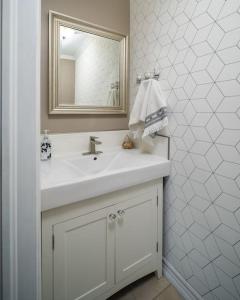 een witte badkamer met een wastafel en een spiegel bij Grand Oasis Napanee in Napanee