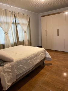 卡內拉的住宿－Lar Serra Gaúcha，一间卧室设有一张床和一个大窗户