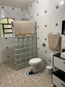 a bathroom with a toilet and towels on a wall at Lar Serra Gaúcha in Canela