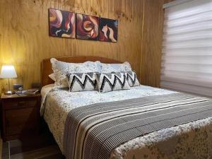 a bedroom with a bed with a wooden head board at Cabaña el Arrayan Futaleufú in Futaleufú