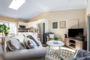 sala de estar con sofá y cocina en Seascape Suite by IRIS PROPERTIES!, en Sooke