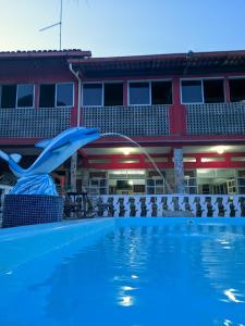 uma piscina em frente a um edifício em Villa Coelho - Pousada a 5 minutos de Guarajuba em Camaçari