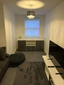 a living room with a couch and a window at Modern Huddersfield apartment in Huddersfield