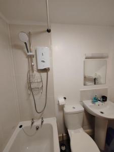 Baño blanco con aseo y lavamanos en Modern Huddersfield apartment en Huddersfield