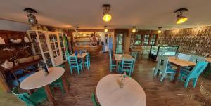 un ristorante con tavoli in legno e sedie blu di Hotel Boutique Arca Restaurant Achao Quinchao Chiloe ad Achao