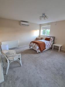 a bedroom with a bed and a chair and a window at Mesa property services in Grays Thurrock