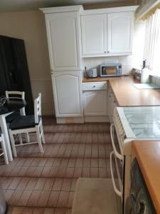 a kitchen with white cabinets and a tiled floor at Mesa property services in Grays Thurrock