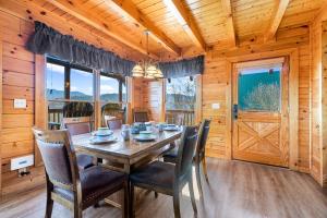 a dining room with a wooden table and chairs at A Higher Calling, 1089 of FREE area attraction tickets for each paid day, Dollywood and More! in Pigeon Forge