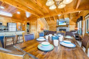 a dining room with a wooden table and a kitchen at A Higher Calling, 1089 of FREE area attraction tickets for each paid day, Dollywood and More! in Pigeon Forge