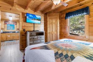 a bedroom with a bed and a flat screen tv at A Higher Calling, 1089 of FREE area attraction tickets for each paid day, Dollywood and More! in Pigeon Forge