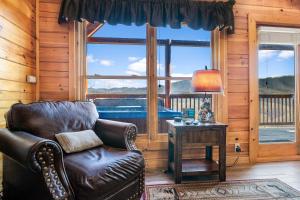 a living room with a leather chair and a window at A Higher Calling, 1089 of FREE area attraction tickets for each paid day, Dollywood and More! in Pigeon Forge