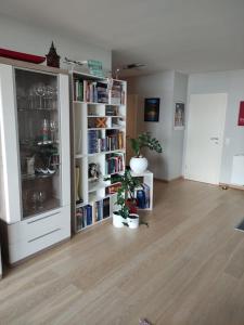 ein Wohnzimmer mit einem Bücherregal mit Büchern in der Unterkunft Schönes Feriendomizil mit Meerblick Südstrand Nähe Fliegerdeich in Wilhelmshaven in Wilhelmshaven