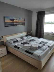 ein großes Bett in einem Schlafzimmer mit Fenster in der Unterkunft Schönes Feriendomizil mit Meerblick Südstrand Nähe Fliegerdeich in Wilhelmshaven in Wilhelmshaven