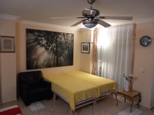 1 dormitorio con 1 cama amarilla y 1 silla negra en Beach&Lake Apartment Studio 55 m², en Hamburgo