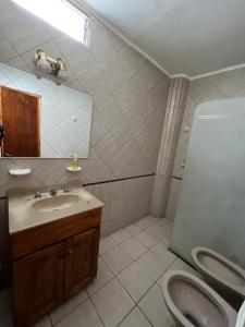 ein Badezimmer mit einem Waschbecken, einem WC und einem Spiegel in der Unterkunft Complejo Alberdi - Alquiler temporario in San Rafael