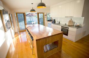 a kitchen with a wooden island in the middle of a room at SUNNY DAZE in Point Lonsdale