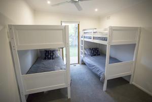 2 Etagenbetten in einem Zimmer mit Fenster in der Unterkunft SUNNY DAZE in Point Lonsdale