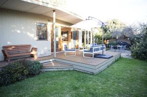 a patio with chairs and a bench on the grass at SUNNY DAZE in Point Lonsdale