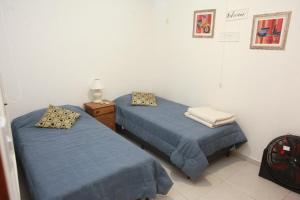 2 camas en una habitación con sábanas azules y mesita de noche en Complejo Alberdi - Alquiler temporario en San Rafael
