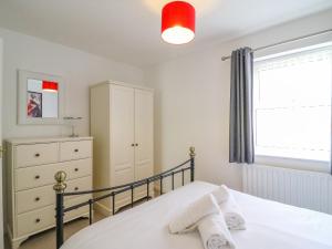 una camera con letto, cassettiera e finestra di Maisy Cottage a Weymouth