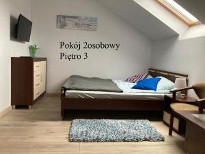 1 dormitorio con 1 cama con un cartel en la pared en Krysia - tuż przy plaży, en Mielno