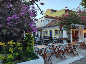 an outdoor patio with tables and chairs and flowers at Pousada L'étage in Búzios