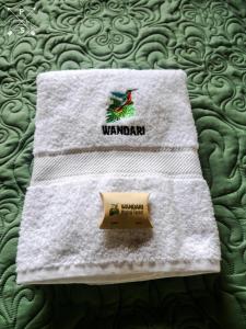 a white towel with a box on a bed at Wandari Lodge in Quince Mil