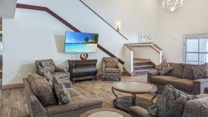 a living room with couches and a flat screen tv at Estherville Hotel & Suites in Estherville
