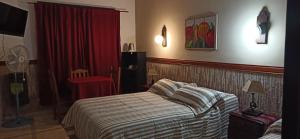 1 dormitorio con cama y cortina roja en ENTRESIERRAS Y RIO en Santa Rosa de Calamuchita