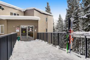 una casa con una puerta y esquís en la nieve en Iron Horse Studio D4064, en Winter Park