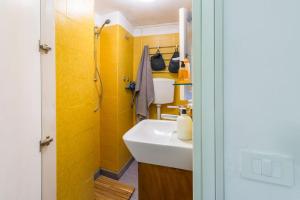 ナポリにあるCasetta Novaの黄色の壁のバスルーム(白い洗面台付)