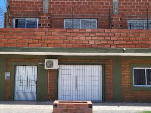 un edificio de ladrillo con tres puertas de garaje con un aro de baloncesto en Hostal Nazarena Herrera en Salta