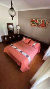 - une chambre avec un grand lit et une couverture rouge dans l'établissement “Chalet Carrasco” totalmente equipado, à Mar del Plata