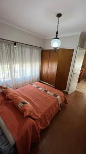 1 dormitorio con 1 cama grande con manta roja en “Chalet Carrasco” totalmente equipado en Mar del Plata