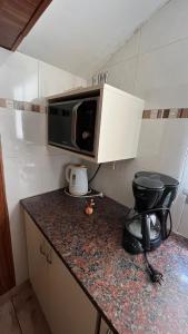 a kitchen with a counter with a microwave and a toilet at “Chalet Carrasco” totalmente equipado in Mar del Plata