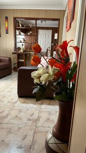a living room with a vase with flowers in it at “Chalet Carrasco” totalmente equipado in Mar del Plata