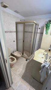 uma casa de banho com um chuveiro, um WC e um lavatório. em “Chalet Carrasco” totalmente equipado em Mar del Plata