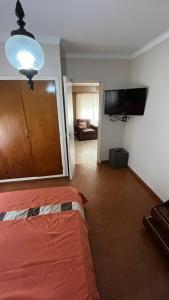 a bedroom with a bed and a living room at “Chalet Carrasco” totalmente equipado in Mar del Plata
