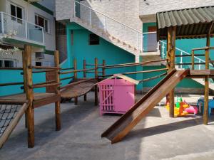 une aire de jeux avec des escaliers en bois et une boîte rose dans l'établissement Canto Verde Aptos I, à Caraguatatuba