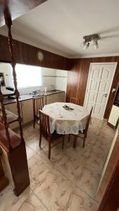 “Chalet Carrasco” totalmente equipado في مار ديل بلاتا: غرفة طعام مع طاولة ومطبخ