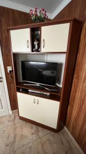 a entertainment center with a microwave and a television at “Chalet Carrasco” totalmente equipado in Mar del Plata