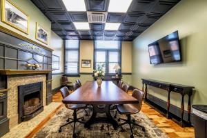 a dining room with a table and a fireplace at City Hall Grand Hotel in Williamsport