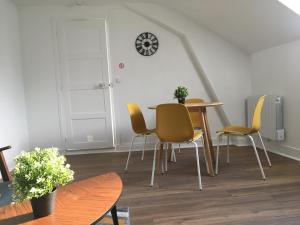 uma sala de jantar com uma mesa e cadeiras amarelas em Le René Pouteau em Melun