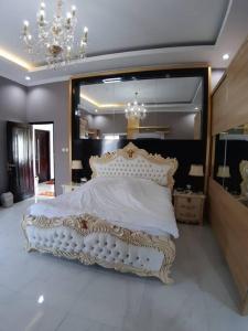 Schlafzimmer mit einem weißen Bett und einem großen Spiegel in der Unterkunft TITE homestay. Staycation feels @home in Salakan